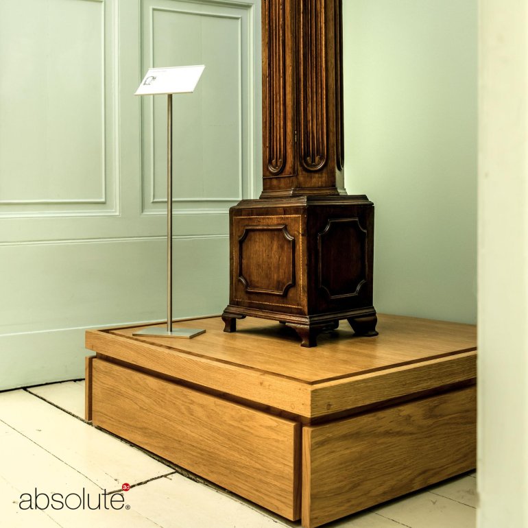 Pinnacle label holder displaying descriptive information for a museum display on wooden stand. 